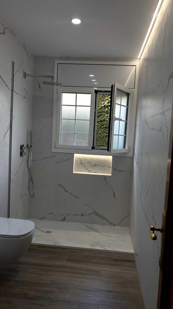 Baño con paredes de mármol, ducha a ras de suelo con iluminación LED y suelo de madera