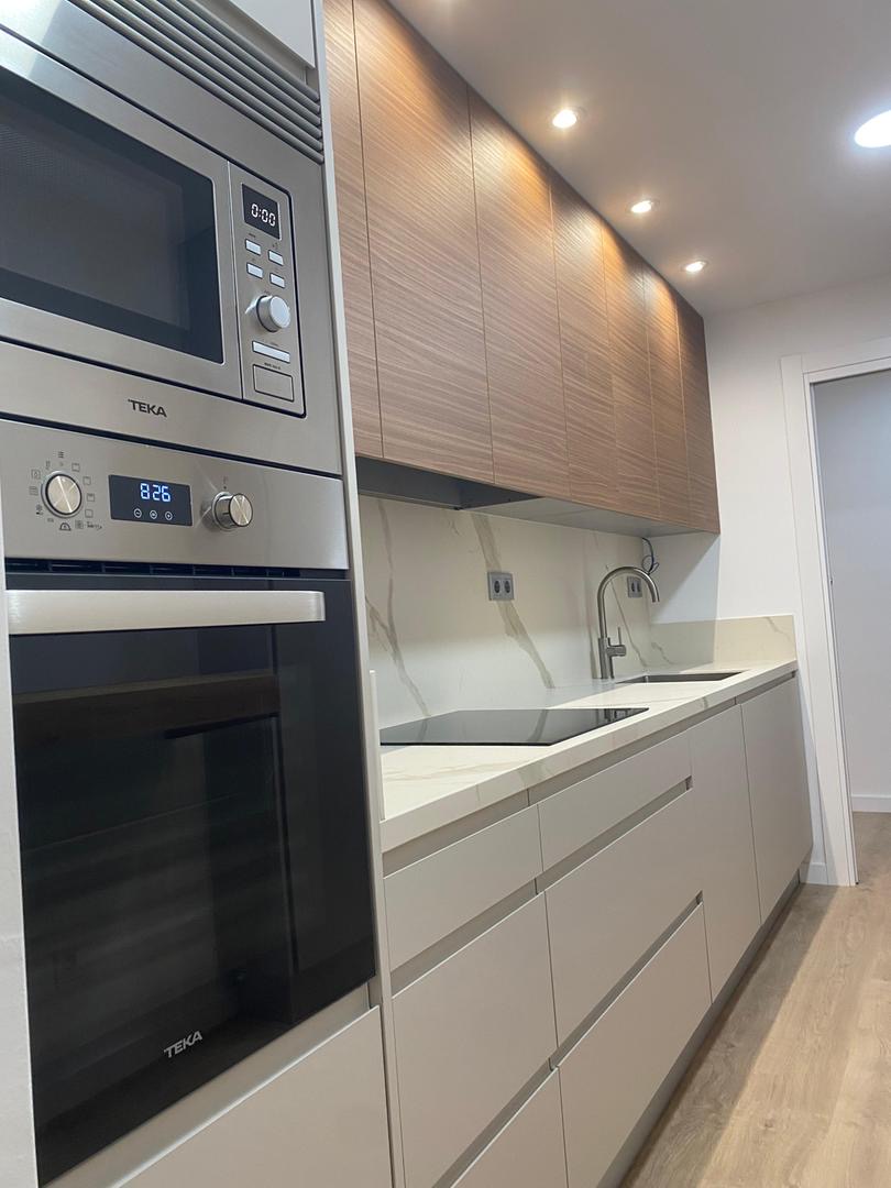 Cocina con muebles de madera, horno y microondas integrados Teka