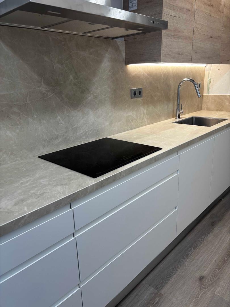 Detalle de cocina con placa de inducción y encimera de piedra natural