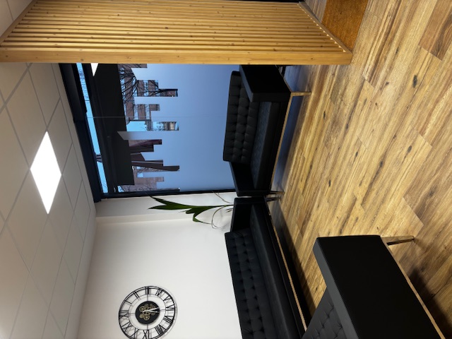 Salón reformado con suelo de madera, terraza y mueble de TV